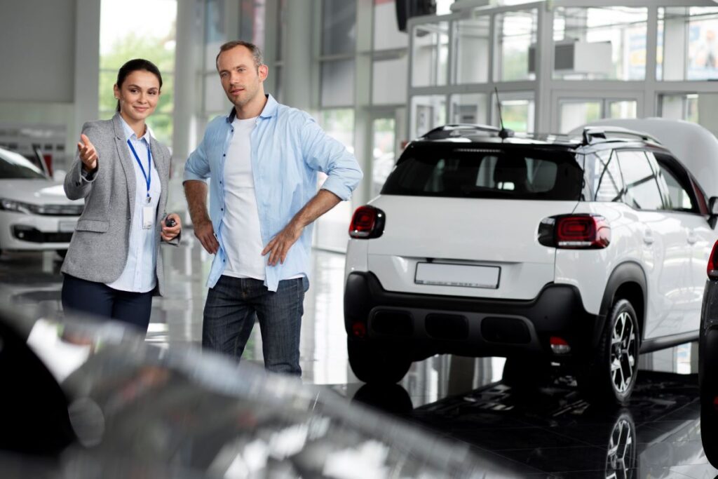 An image of a man and woman standing beside a car.